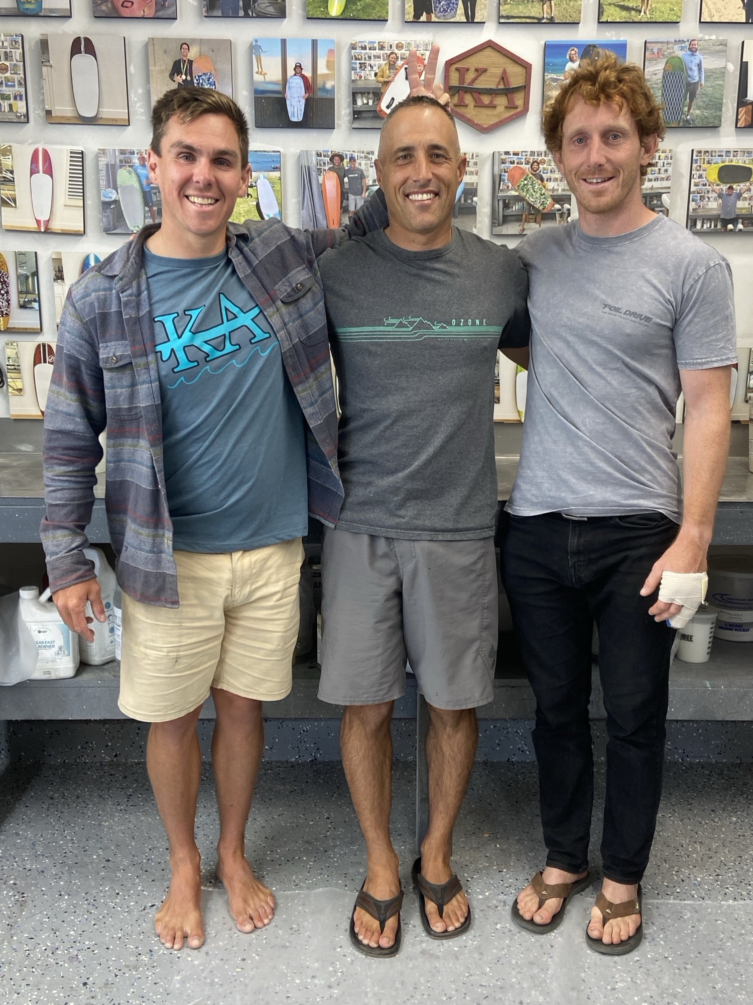 Three mates in front of a wall of boards